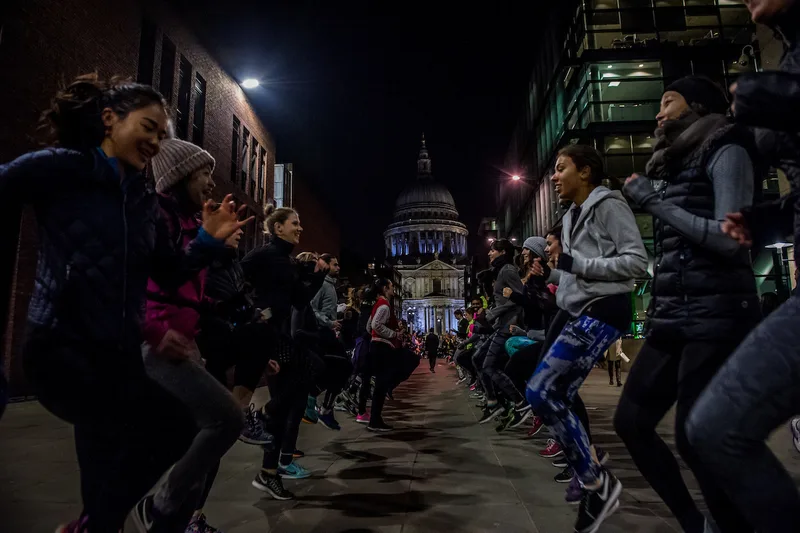 Chevy Rough leading a running seminar with St Paul's Cathedral in the background, London
